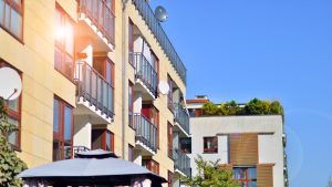 Façade moderne d'une résidence sous un ciel bleu, idéale pour l'achat d'un premier appartement à Montpellier avec balcons et terrasses végétalisées