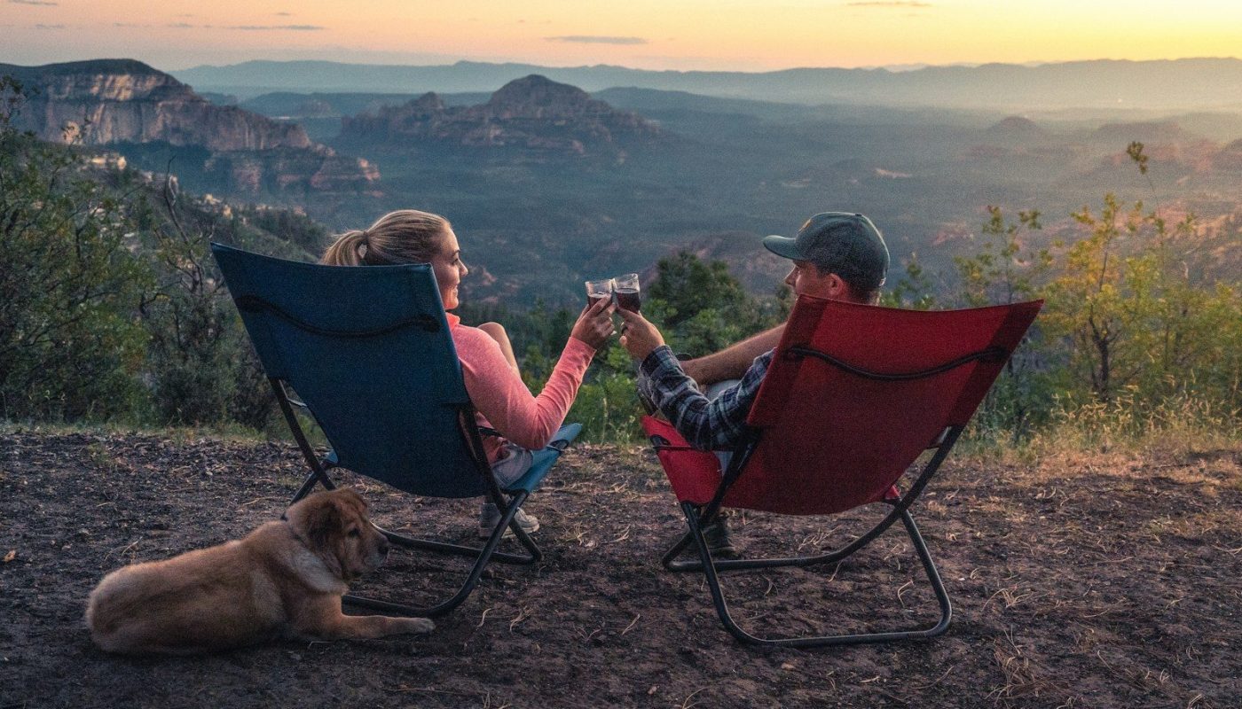two person sitting on camping chairs while watching mountain