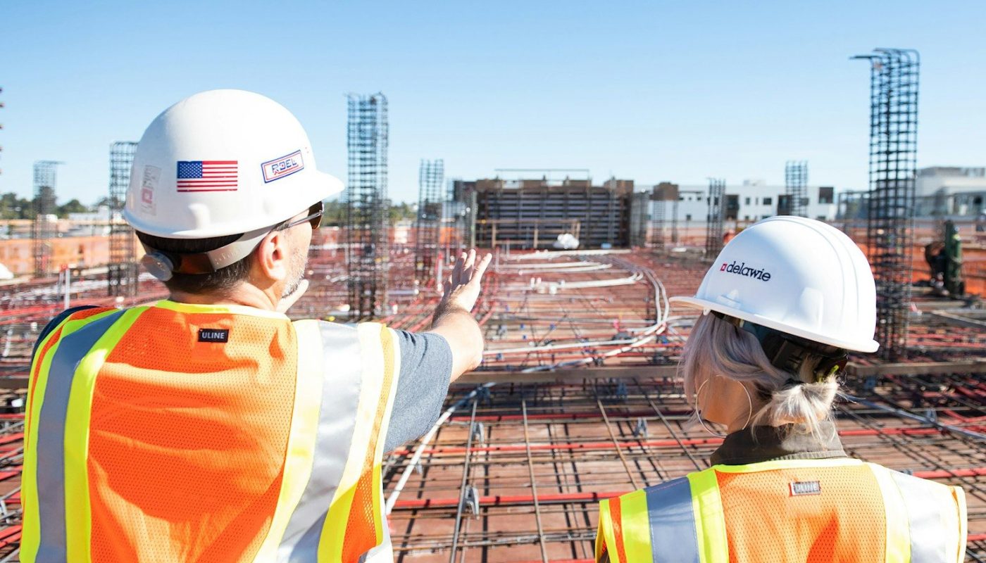 two construction workers in safety vests at site