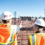 two construction workers in safety vests at site