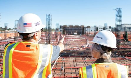 two construction workers in safety vests at site
