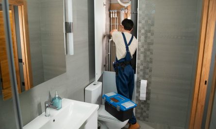 A plumber repairs plumbing in a bathroom.