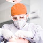 a man getting his teeth brushed by a dentist