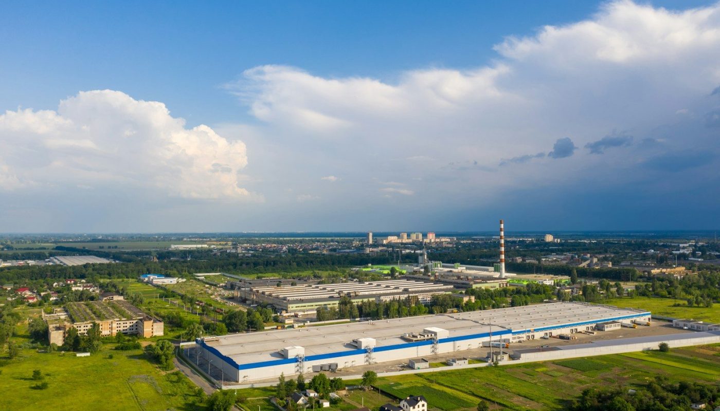 white and blue building near green grass field under blue sky during daytime