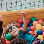 girl in blue shirt lying on yellow inflatable pool