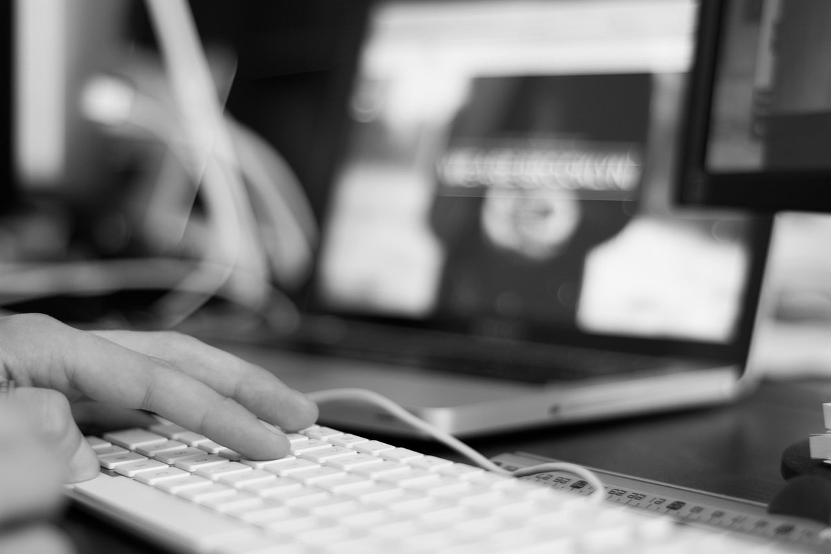 Clavier et écran d'ordinateur avec des mains tapant dessus