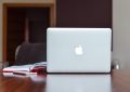 Ordinateur portable Apple sur table en bois avec cahier ouvert