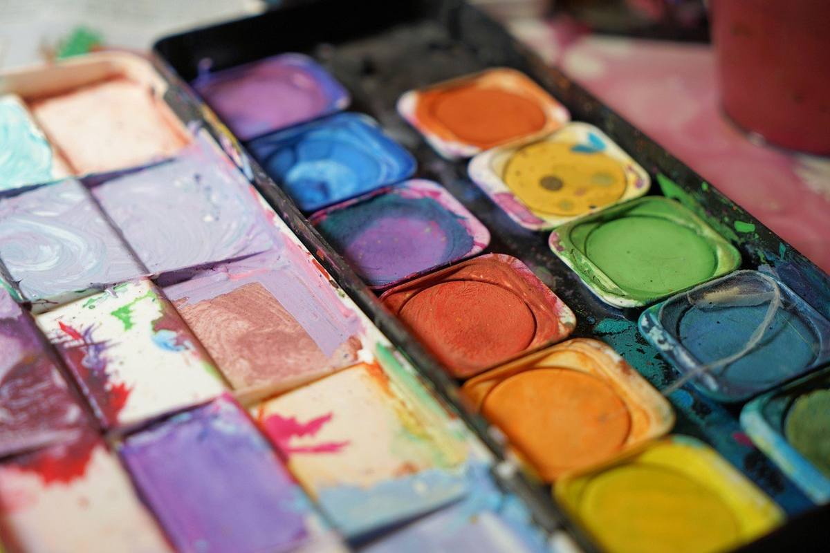 Palette d'aquarelle avec des couleurs vives et des pinceaux sur une surface Palette d'aquarelle avec des couleurs vives et des pinceaux sur une surface